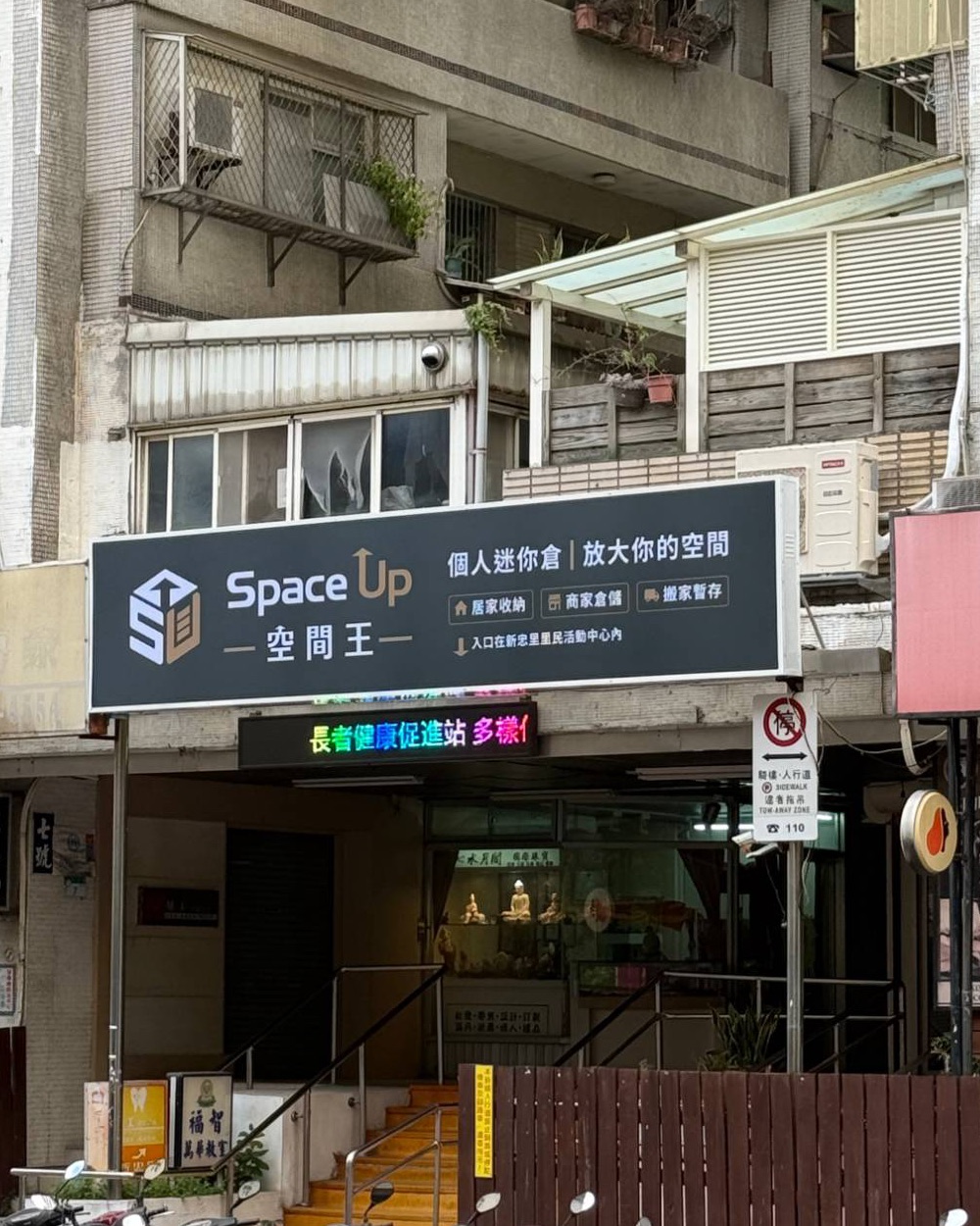 西藏路上的空間王招牌，招牌下方樓梯通往新忠里里民活動中心